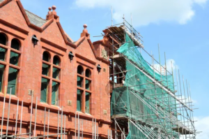 Red brick building undergoing renovation with professional masonry scaffolding